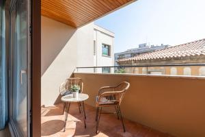 a patio with two chairs and a table on a balcony at Bravissimo Falcó, 3 bedrooms and balcony in Girona