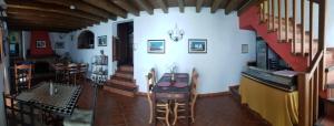 a room with a staircase and a table and chairs at B&B the lost Village el Acebuchal in Frigiliana