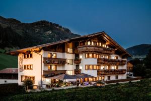 un hotel en las montañas con un edificio en Hotel Alpenhof, en Grossarl