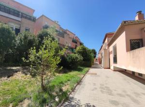 een straat in een oude stad met een boom en gebouwen bij Dúplex La Vega in Cenes de la Vega