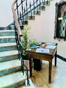 una mesa junto a una escalera con una mesa de madera y una mesa en Senhor Gigi en Faro