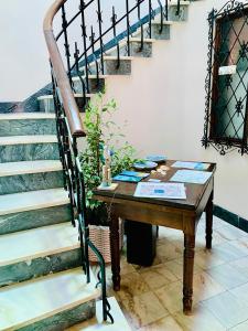 a table next to a staircase with a wooden table and a table at Senhor Gigi in Faro