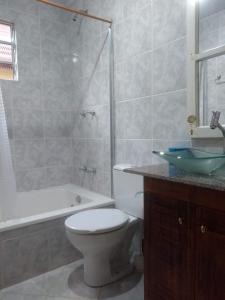 y baño con aseo, lavabo y bañera. en Casa aconchegante em Canela, en Canela