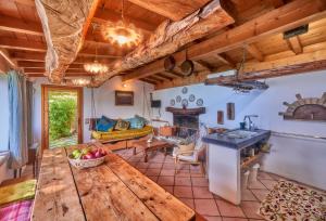 een keuken en een woonkamer met een houten plafond bij piccola casa naturale sul lago in Varenna