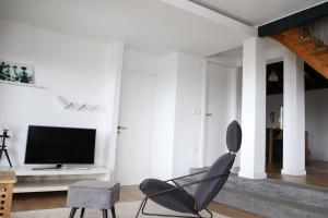 a living room with a chair and a television at Villa Capelinhos in Capelo