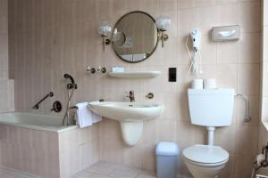 La salle de bains est pourvue d'un lavabo, de toilettes et d'un miroir. dans l'établissement Hotel Schlömer, à Cloppenburg