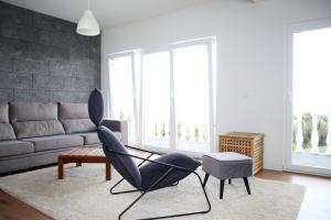 a living room with a black chair and a couch at Villa Capelinhos in Capelo
