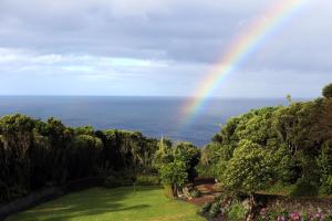een regenboog in de lucht boven de oceaan bij Villa Capelinhos in Capelo