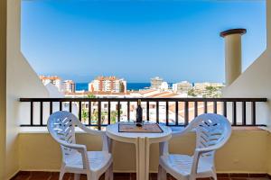 een tafel en 2 stoelen op een balkon met uitzicht bij Klayman Olivina Aparthotel in Los Cristianos