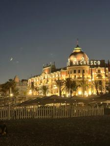 a large building lit up at night with lights at NICE - Central 100m plage- Negresco - IDEAL COUPLE in Nice