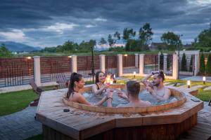 a group of people sitting in a hot tub at Roots Villa Redwood in Braşov