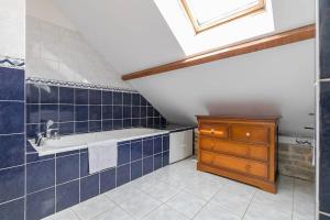 La salle de bains est pourvue d'un lavabo et de carrelage bleu. dans l'établissement Le Montrachet, à Dijon 12 autres photos