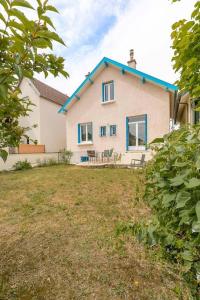 ein weißes Haus mit einem blauen Dach und einem Hof in der Unterkunft Le Montrachet in Dijon