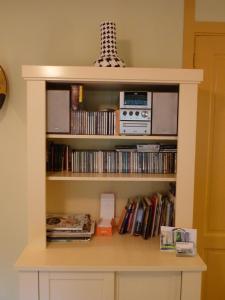 a book shelf filled with books and dvds at B&B Pakhuis Emden in Groningen