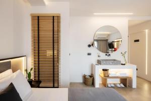 a bedroom with a bed and a mirror at Neapolis 21 Suites, Premium Key Collection in Skiathos Town
