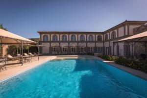 una grande piscina di fronte a un edificio di Relais La Corte dei Papi a Cortona