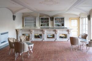 een kamer met een open haard en een tafel en stoelen bij Relais La Corte dei Papi in Cortona