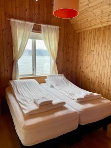 a bed in a room with a window at Ytri Vík in Hauganes