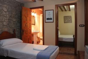 1 dormitorio con 1 cama y baño con lavamanos en Casa Rústica en Villafranca del Cid con vistas a la montaña "Els Arenals", en Villafranca del Cid