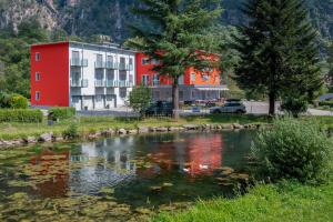 a hotel with a pond in front of a building at Motel Afia in Cama