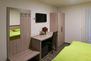 Schlafzimmer mit einem Schreibtisch und einem Bett mit einem Spiegel in der Unterkunft Motel Afia in Cama