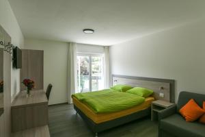 Motel Afia في Cama: غرفة نوم بسرير وملاءات خضراء ونافذة