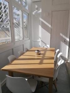 drewniany stół w pokoju z białymi krzesłami w obiekcie Stunning Apartment Marquês de Pombal w Lizbonie