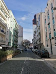 une rue pavée dans une ville avec des bâtiments dans l'établissement Stunning Apartment Marquês de Pombal, à Lisbonne