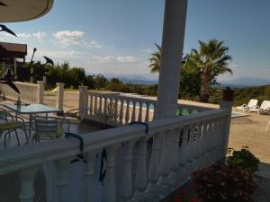 a white railing on a porch with tables and chairs at ΘΕΑ ΠΑΝΟΡΑΜΑ in Paliámpela