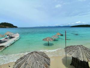 a beach with some umbrellas and the ocean at Lonos Circle Private Garden in Romblon
