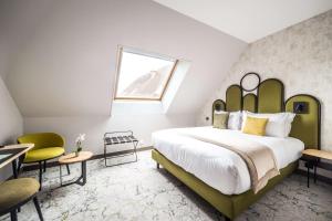 - une chambre avec un grand lit et une tête de lit verte dans l'établissement Best Western Le Relais du Vigneron, à Vertus