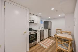 a kitchen with stainless steel appliances and a table and chairs at 1 Bedroom Lower Level Suite in Burlington -The Jacob at Bellwood in Burlington