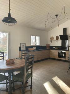 eine Küche und ein Esszimmer mit einem Tisch und Stühlen in der Unterkunft Maison neuve entre Bassin d'Arcachon et Landes 