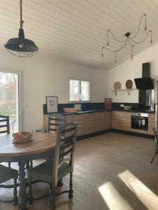 a kitchen and dining room with a table and chairs at Maison neuve entre Bassin d'Arcachon et Landes in Le Muret