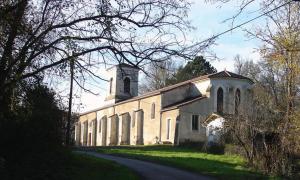 a large white church with a clock tower on a road at Maison neuve entre Bassin d'Arcachon et Landes in Le Muret