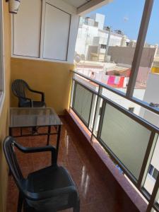 Zimmer mit 2 Stühlen, einem Tisch und einem Fenster in der Unterkunft Pensión La Paloma in Arona