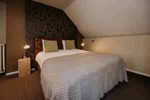 - une chambre avec un grand lit dans l'établissement Villa Westerduin, à Renesse