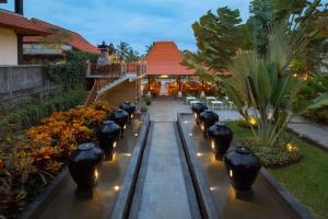 a garden with black vases and lights in front of a building at Best Western Premier Agung Resort Ubud in Ubud