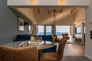 a dining room and living room with a table and chairs at Tidal Reach Dunhallin in Hallin