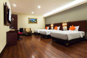 ein Hotelzimmer mit 2 Betten und einem TV in der Unterkunft Best Western Senayan in Jakarta