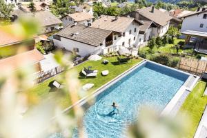 a person swimming in a pool in a house at Hotel Weisses Kreuz in Malles Venosta