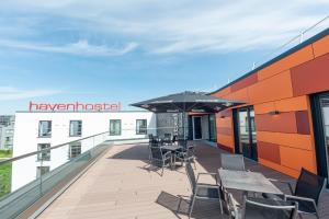 a balcony with tables and chairs on a building at havenhostel Stade - Hotel in Stade