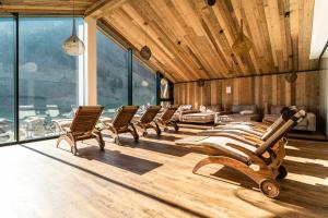 una fila de sillas en una habitación con ventanas en Carpe Solem Rauris by ALPS RESORTS, en Rauris