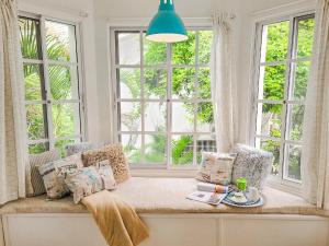 asiento junto a la ventana en una sala de estar con ventanas en Blue Heaven Guest House Bávaro, Punta Cana, Ideal For Couples, en Punta Cana