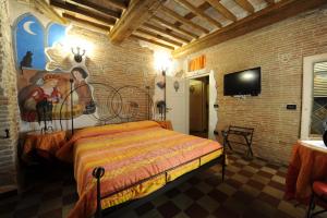 ein Schlafzimmer mit einem Bett in einer Ziegelwand in der Unterkunft Antica Corte dei Principi charming rooms in Lucca
