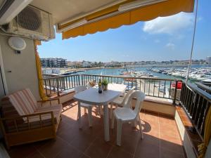 a balcony with a table and chairs and a view of a harbor at Precioso apartamento en primera línea de mar in L'Escala