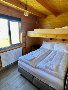 1 dormitorio con 1 cama en una habitación de madera en Ytri Vík, en Hauganes