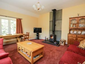 a living room with a couch and a wood stove at Stables Cottage in Langholm