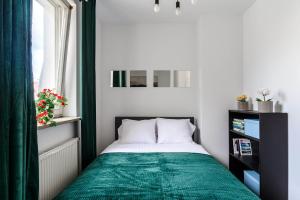 Dormitorio pequeño con cama con manta verde en Lumina lux apart with a balcony near Palace of Culture and Science, en Varsovia