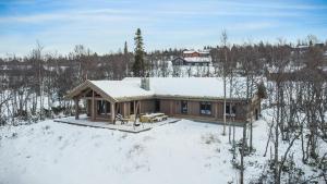 dom w śniegu z śniegiem na dachu w obiekcie NEW LUXUARY Cabin with perfect location on Geilo. w mieście Flatåker